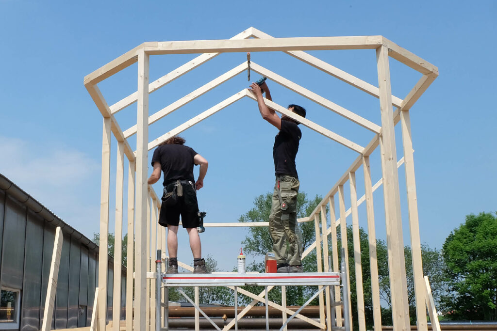 Zwei Kollegen beim Rohbau des Dachgerüsts im Tiny House